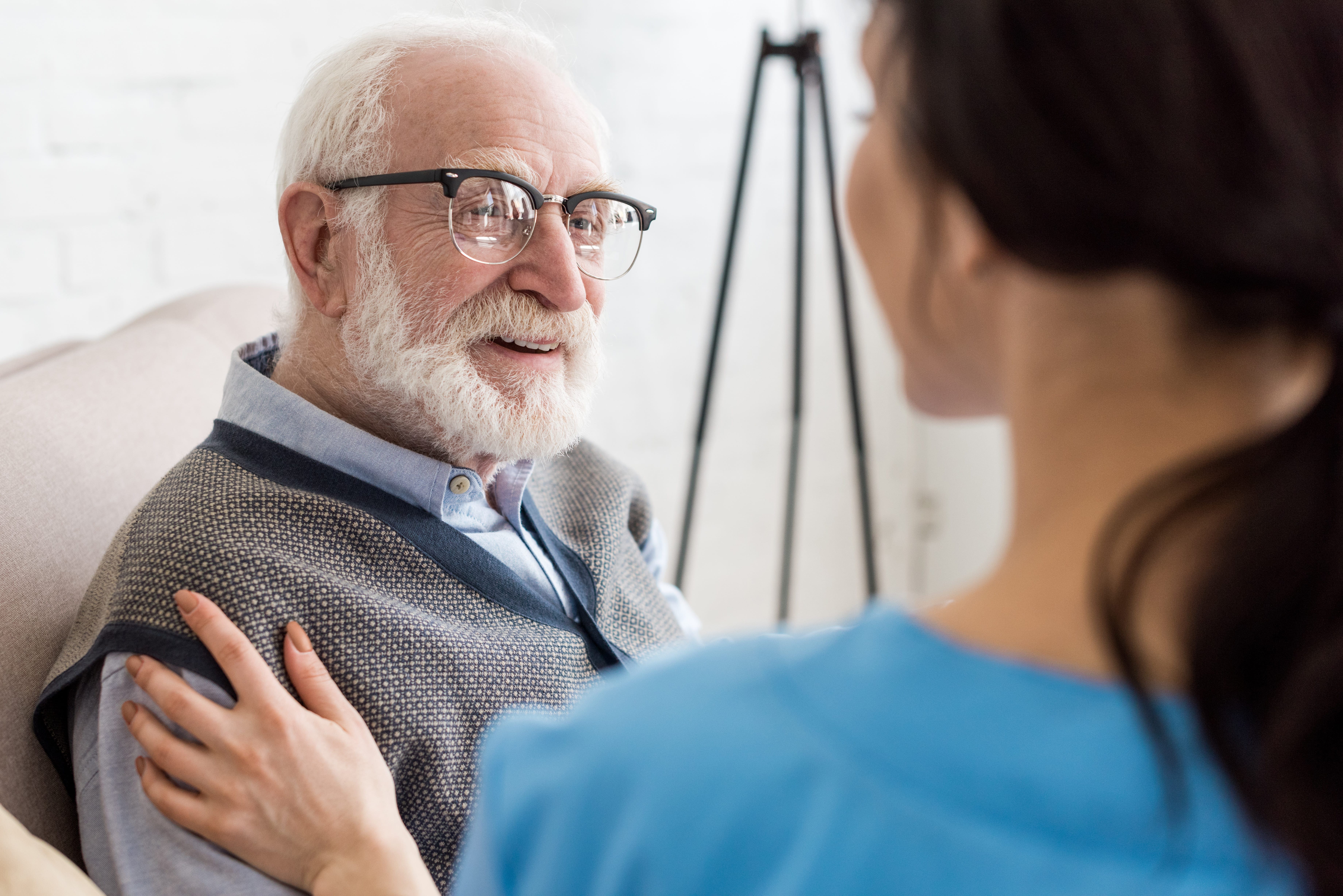 cheerful and grey haired man looking at nurse