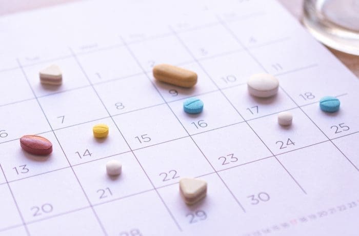 bunch of different pills on a calendar background. concept Healthcare different pills on a calendar