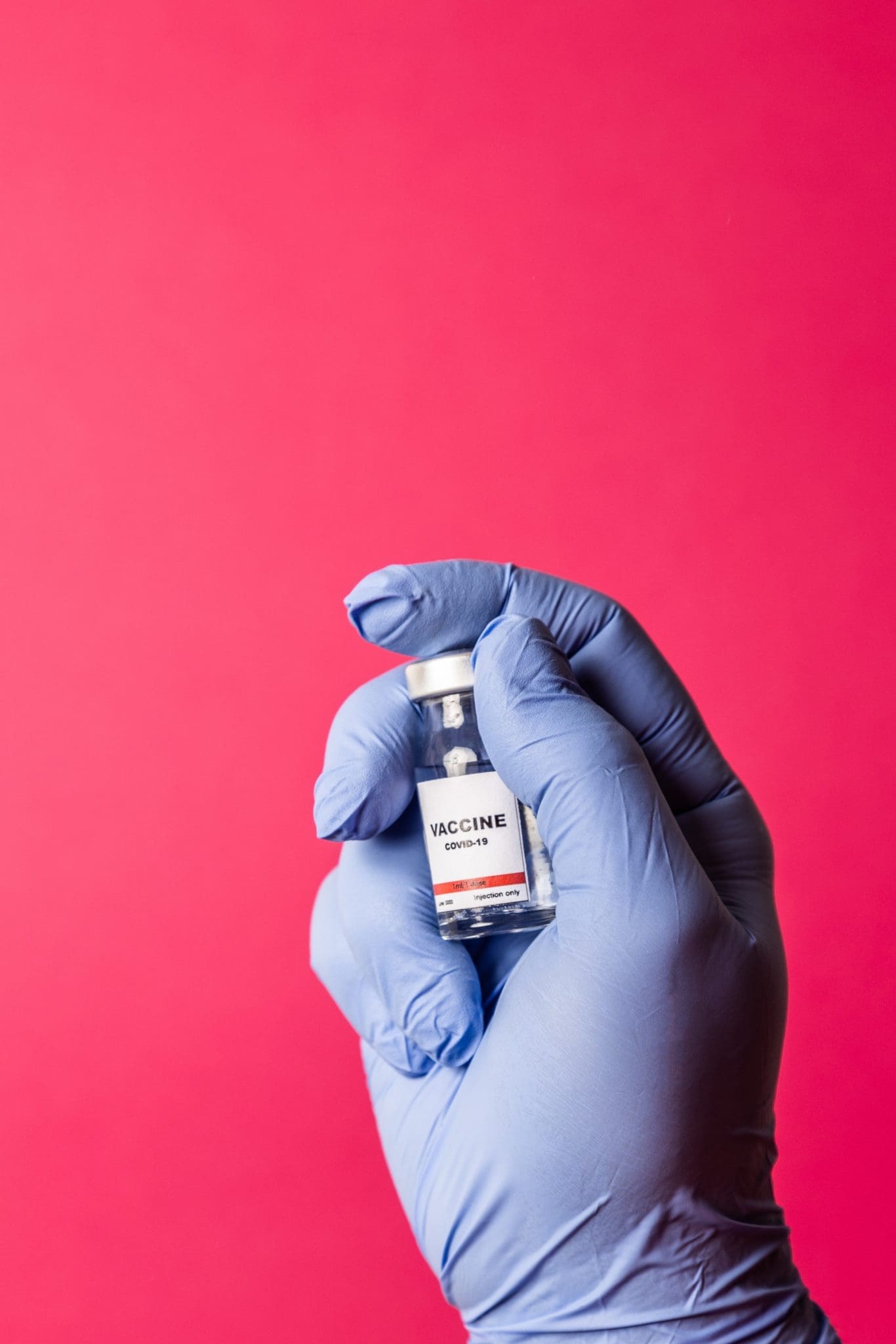 person with glove holding vaccine in hand