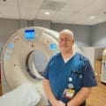 Todd Reynolds, BSRT, CT, MRI standing in front of imaging machine